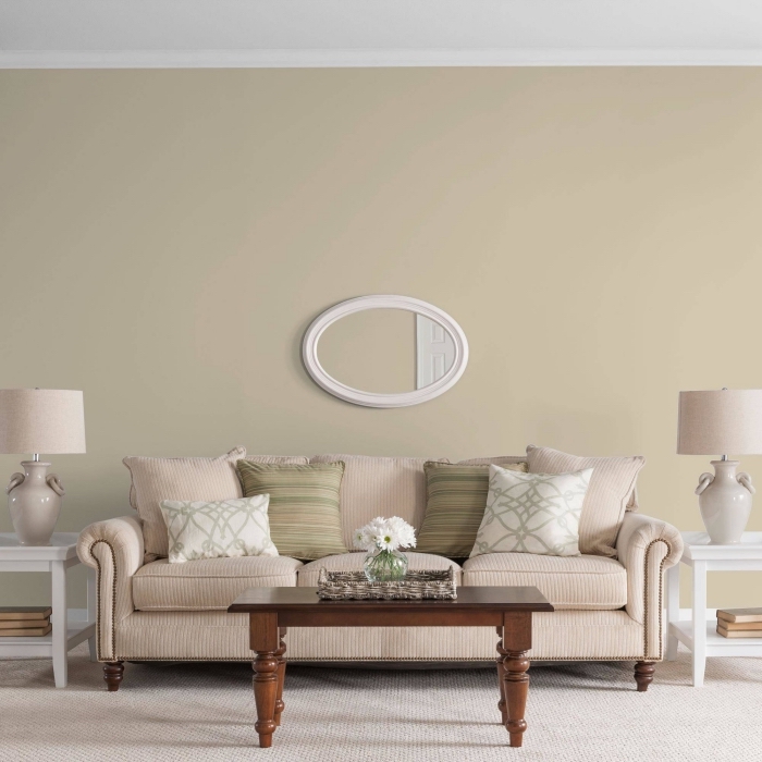peinture beige dans un salon de style vintage aménagé avec meubles en bois blanc et marron foncé et accessoires en nuances pastel