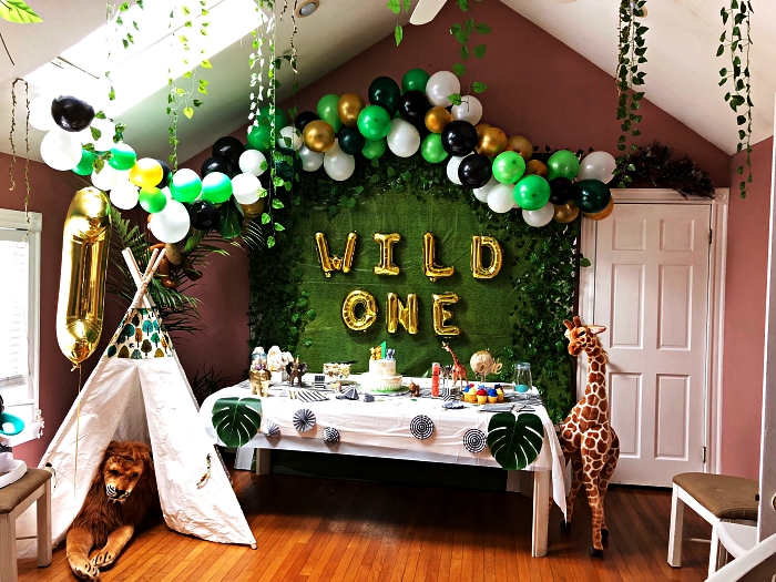 tipi indien, arche de ballons et toile de fond vert pour une decoration anniversaire garçon sur le thème de la jungle