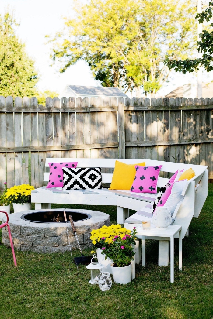 exemple comment aménager son jardin avec feu et banc en bois blanc sur pelouse, modèles de coussins décoratifs colorés