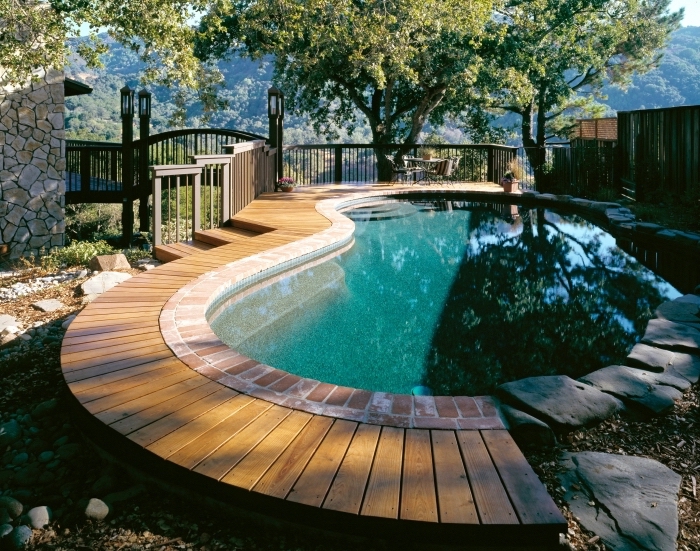 quelle forme pour une piscine, exemple plage de piscine en planches de bois clair, modèle piscine avec bordure pierre