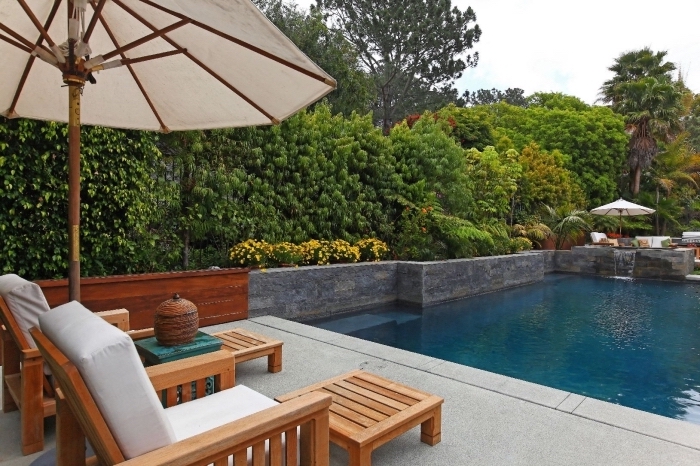 design extérieur piscine et terrasse, modèle de grande piscine avec cascade, meubles de piscine transats en bois