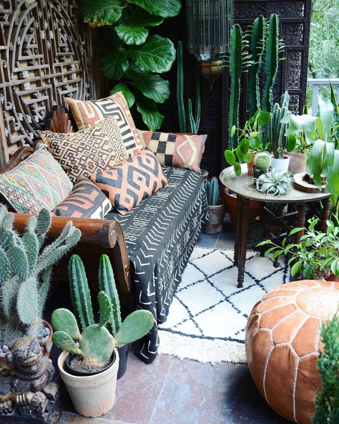 petit jardin aménagé de style tropical avec coussins motifs ethniques et cactus, idée plantes vertes pour extérieur