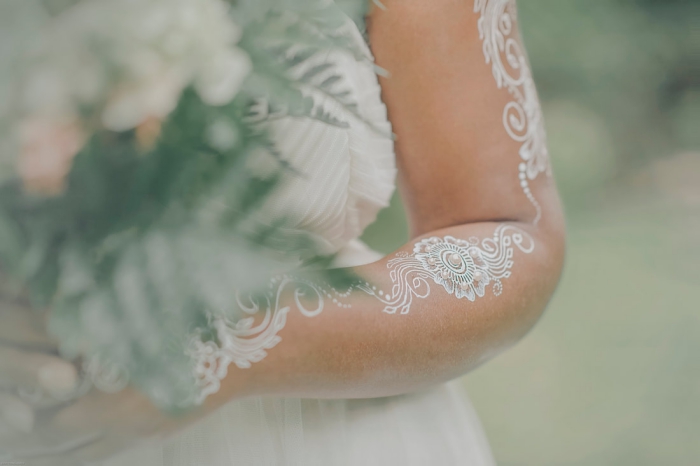 idée art corporel pour mariage, tattoo temporaire sur bras et mains aux motifs feuilles et fleurs avec paillettes