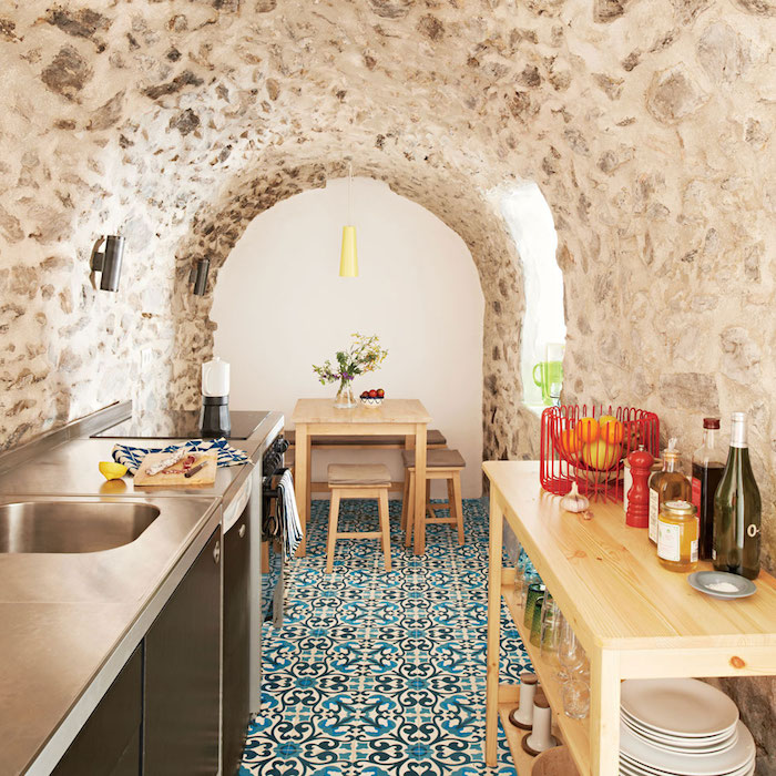 murs de pierre dans une cuisine originale deco marocaine avec carrelage sol mosaique, electromenager inox et table ilot bois