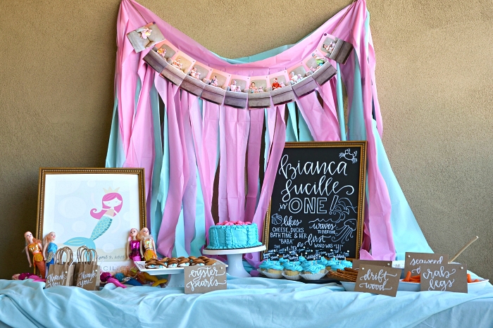 idée pour réaliser une déco de table sur le theme anniversaire petite sirène, candy bar sirène en bleu et rose décoré d'un rideau à franges en toile de fond