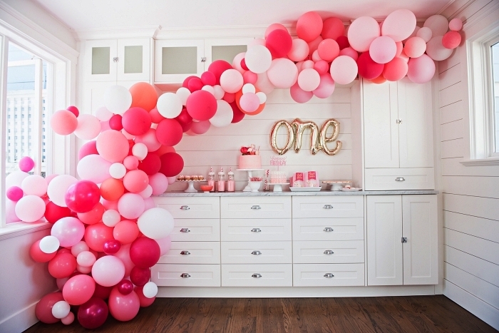 une arche de ballons en camaïeu du rose et des ballons lettres pour la decoration anniversaire bébé 1 an 
