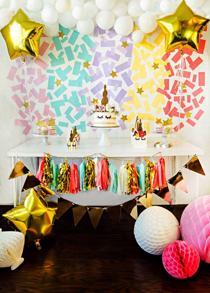 idée déco sur le theme anniversaire licorne, toile de fond de confettis arc-en-ciel et guirlande de ballons blancs pour la décoration du buffet gourmand