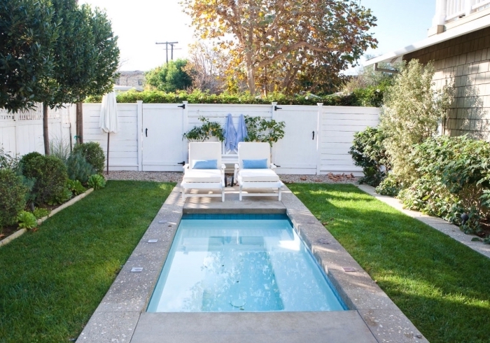 comment décorer une petite cour arrière avec petite piscine rectangulaire et jardin vert, meuble de piscine transats