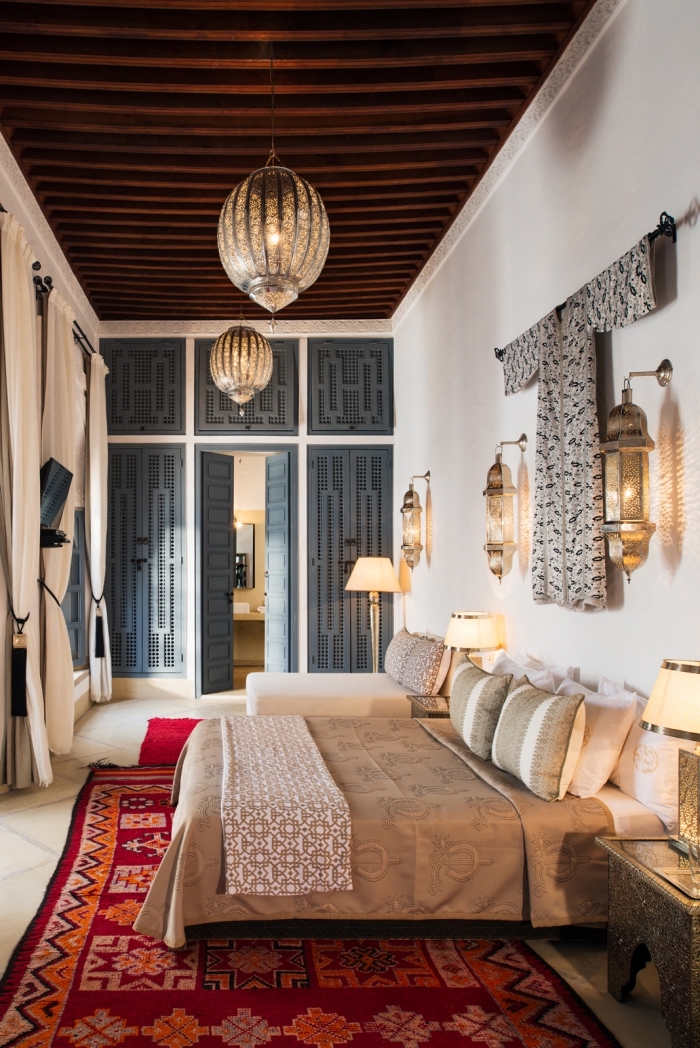 déco petite chambre à coucher au plafond haut en bois foncé aménagée de style marocain, idée tête de lit avec lampe et vêtements traditionnels