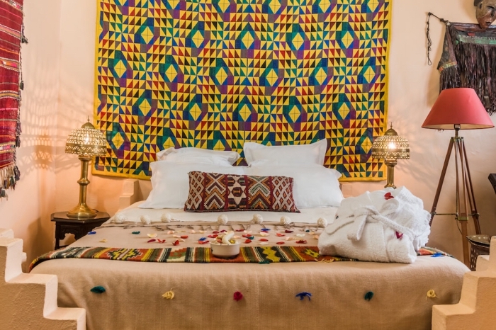 exemple de tete de lit originale en tissu, décoration chambre à coucher orientale avec lampes marocaines et jet de lit multicolore ethnique