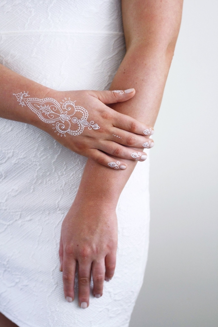 idée tatouage temporaire pour doigts et main, exemple de tattoo henné en blanc, modèle henné main aux motifs ethniques