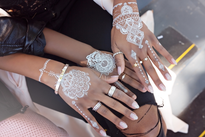 exemple de tatouage au henné pour main, idée tattoo éphémère en blanc aux motifs flèche et mandala à effet bracelet 