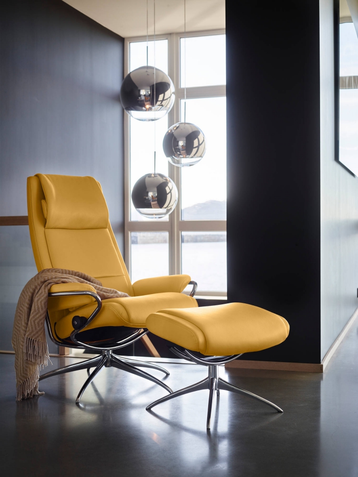 design intérieur moderne dans un salon aux murs foncés avec lampes suspendues, exemple de fauteuil relaxant avec repose-pied en cuir jaune moutarde