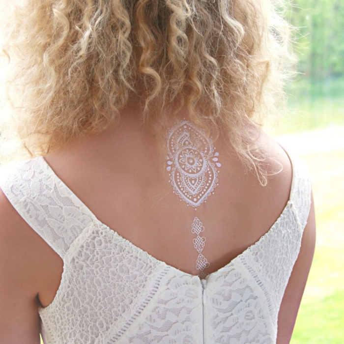 exemple de tatouage éphémère sur dos, modèle de tatouage bohème en blanc aux motifs géométriques sur le dos