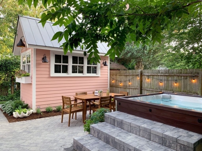 idée déco de jardin avec piscine, modèle de clôture en bois décorée avec guirlande lumineuse, meuble de jardin en bois