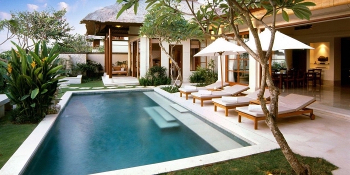 décoration jardin vert avec grande piscine et terrasse en carrelage blanc, modèle de transats piscine en bois et blanc