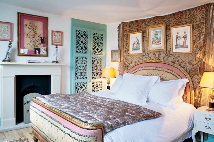 idée décoration chambre à coucher aux murs blancs avec plancher bois et cheminée, tete de lit velours avec cadre bois doré
