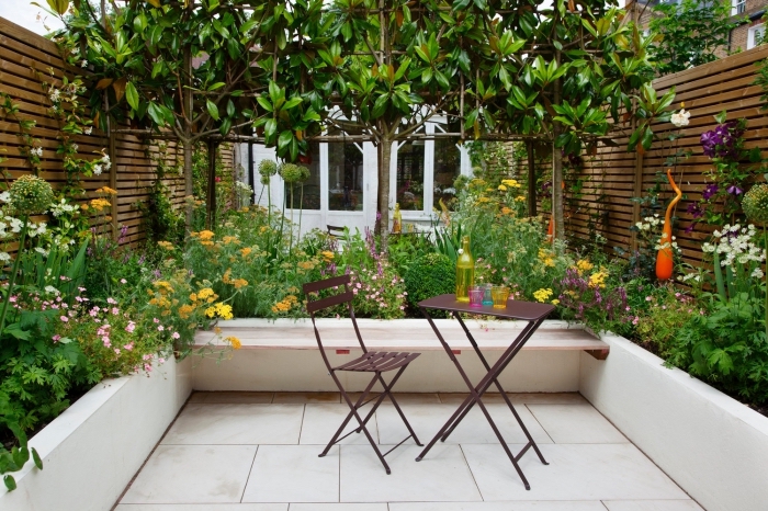 design extérieur pour petit espace, déco de jardin avec plantes et clôture en bois foncé, meuble jardin pliant