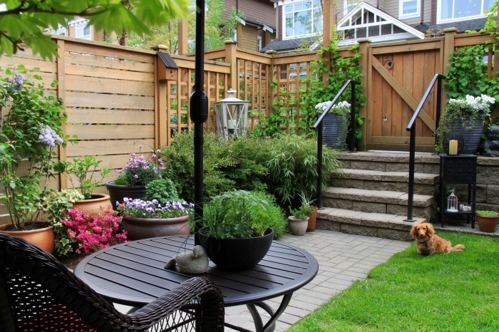 aménagement cour arrière avec clôture en bois, déco de petit jardin avec pelouse et coin de repos aménagé avec chaise tressée