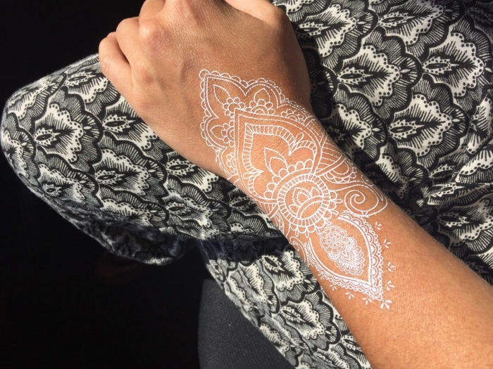 modèle de tatouage mandala blanc sur main, idée dessin henné sur main, exemple de tatouage temporaire blanc