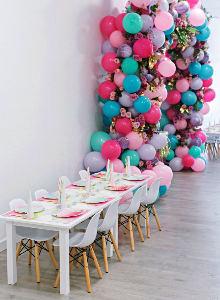 deco table anniversaire sur le thème licorne avec un set de table iridescent, arche de ballons rose, bleu et violet
