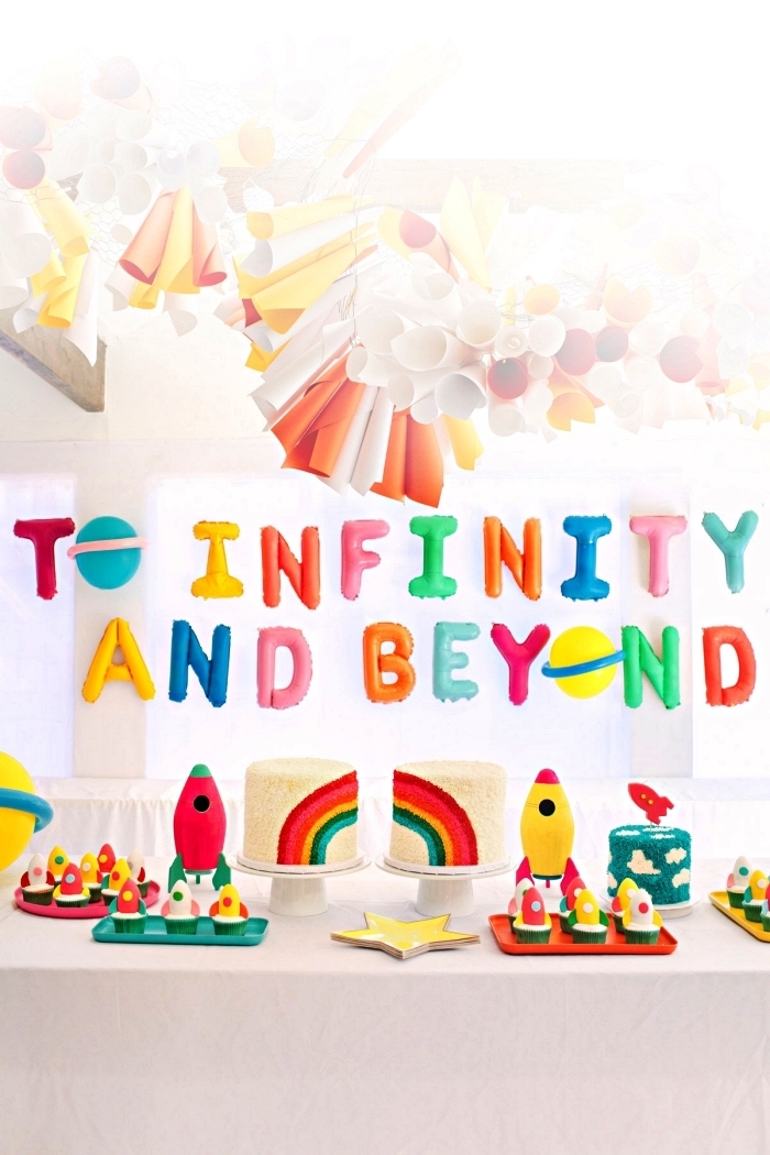 deco table anniversaire sur le thème espace avec ballons lettres colorés et une guirlande en papier, candy bar sur le thème de l'espace