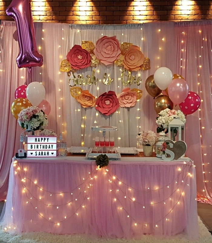 deco table anniversaire 1 an rose, table d'anniversaire fille décorée de guirlande led, jupe de table en tulle, ballons et fleurs