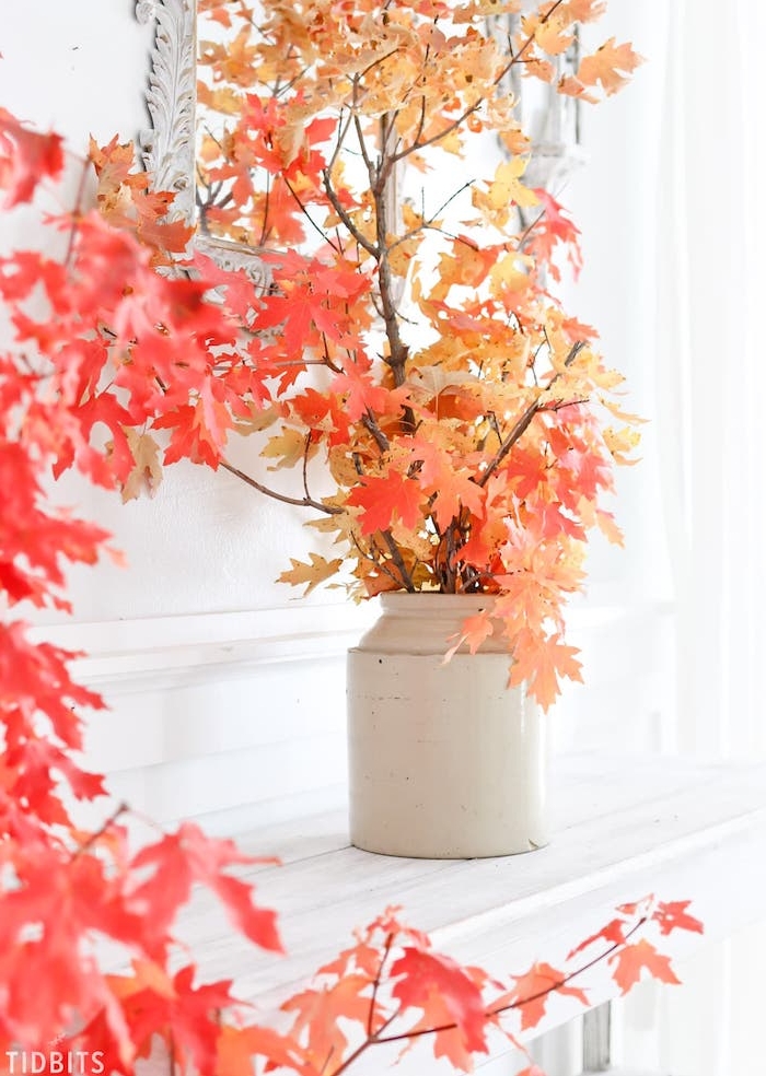 idée de branches avec des feuilles d automne dans un vase blanc sur le bord d une cheminée blanche, idée d activité automne