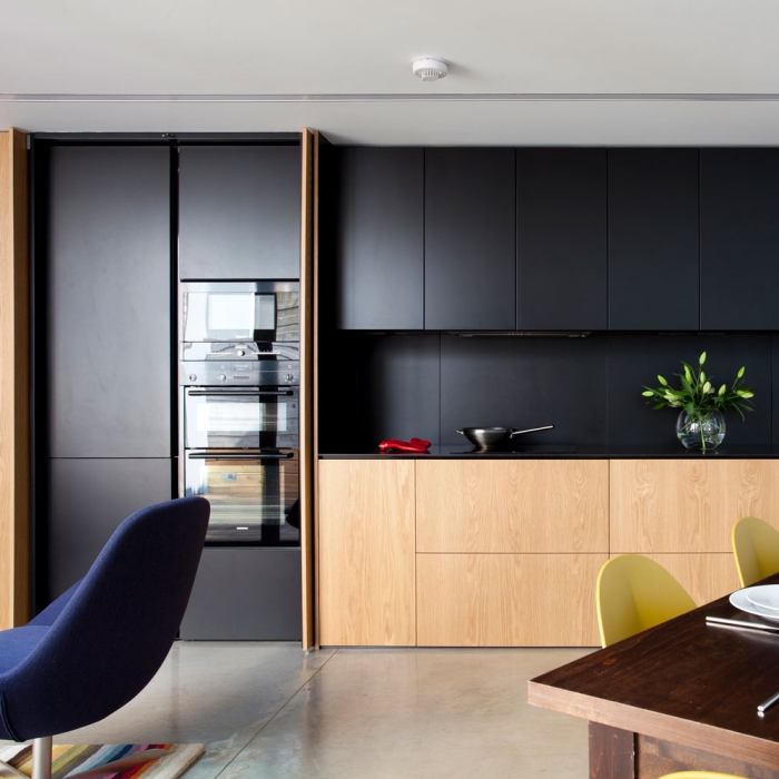 comment aménager une cuisine moderne en longueur, exemple de cuisine noire et bois au plancher effet ciment