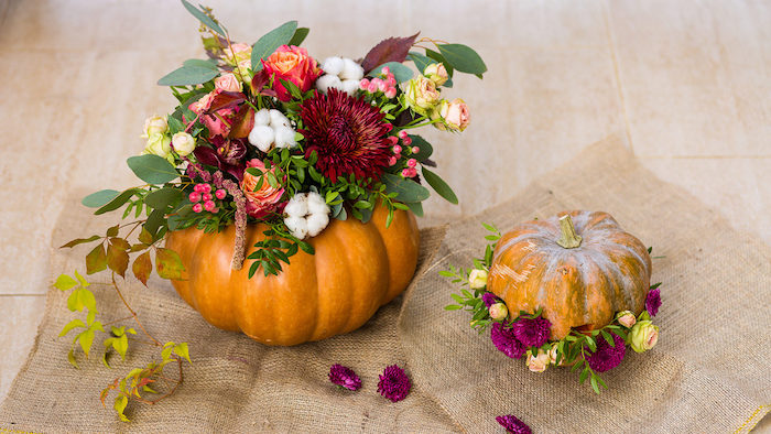 centre de table fleurie, idee deco table automne avec bouquet de fleurs dans une citrouille halloween creusée