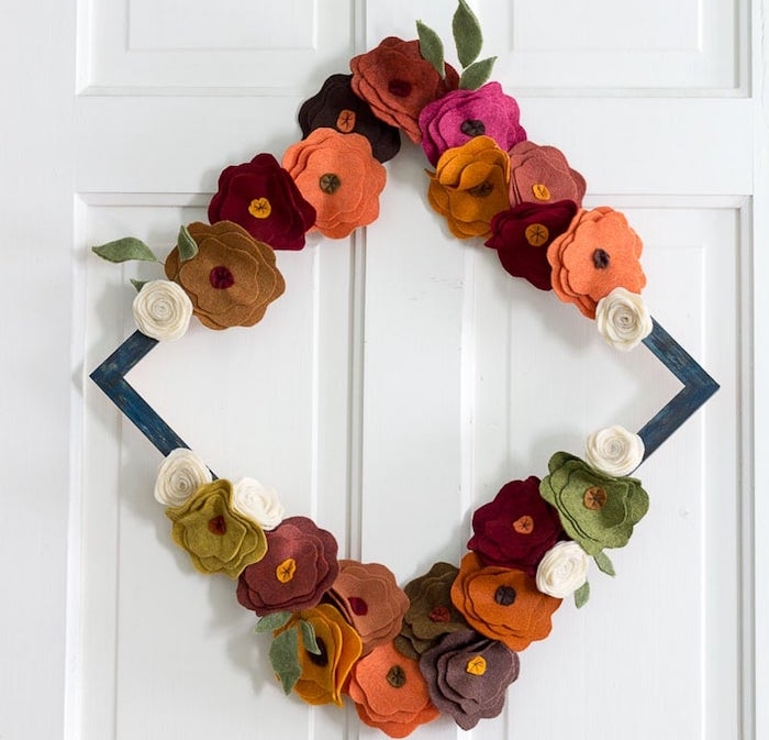 faire une couronne d automne de fleurs de feutrine aux couleurs automnales collées sur un cadre de bois pour creer une deco de porte