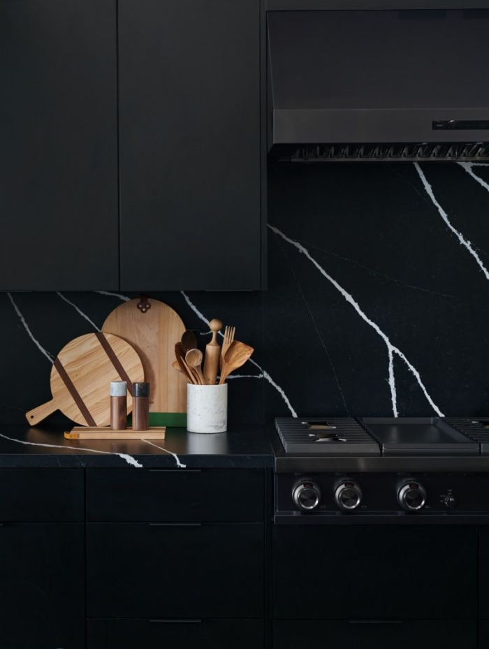 design contemporain dans une cuisine look total noir avec meubles haut cuisine en noir mat et crédence marbre noir