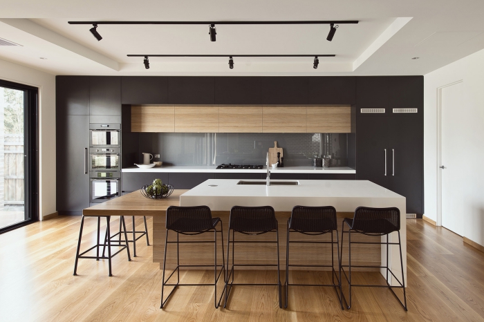aménagement cuisine linéaire avec îlot table à manger, décoration cuisine bois et noir avec crédence gris et accents blancs