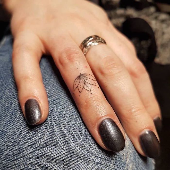 Doigt tatouage fleur discret, superbe idée de dessin sur la peau fleur de lotus, tatouage minimaliste sur le doigt, manucure gris, anneau or