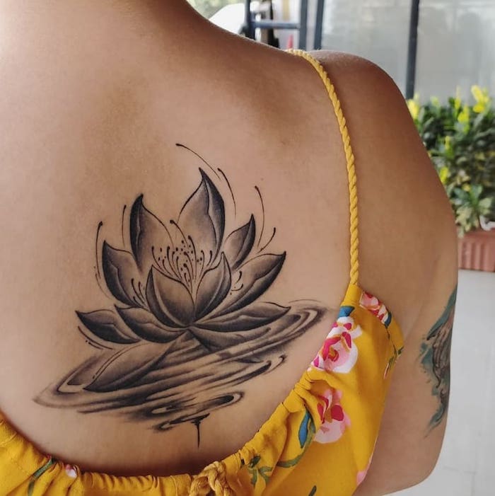 Dos femme tatouage lotus dans l'eau, zen tatou à grande signification fleur de lotus, symbole tatouage fleur de lotus