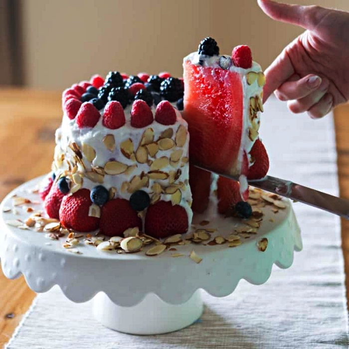 gâteau de pastèque nappé de crème au mascarpone au décor de fruits rouges et d'amandes effilées, idée de dessert facile et rapide et original