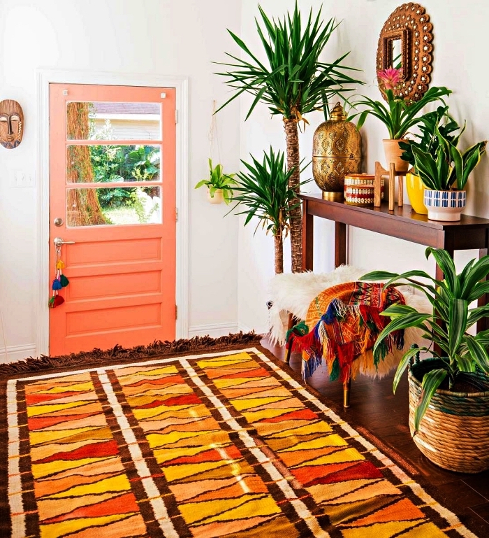 décoration d'entrée bohème chic avec des plantes vertes variées, des accessoires en bois et osier et un tapis ethnique multicolore
