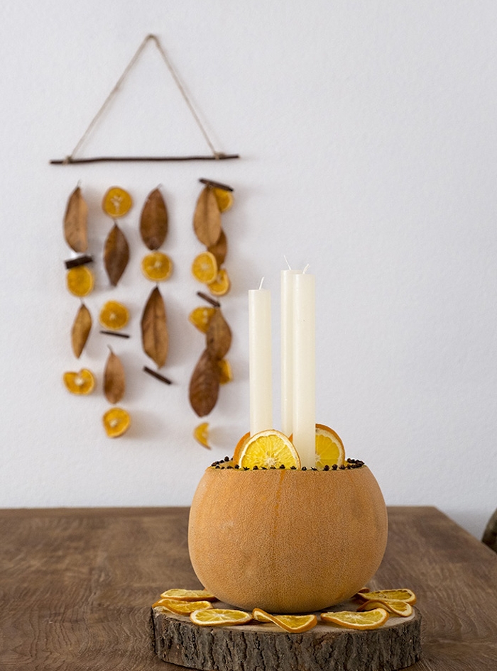 mobile deco murale bois flotté avec tranches d orange séchées et feuilles d automne, centre de table potiron avec bougies sur rondin de bois et tranches d orange