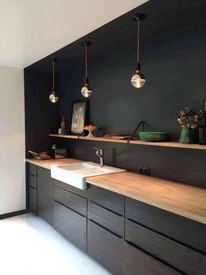 agencement cuisine linéaire en noir avec plan de travail bois, déco cuisine noire et bois avec plafond et plancher blancs