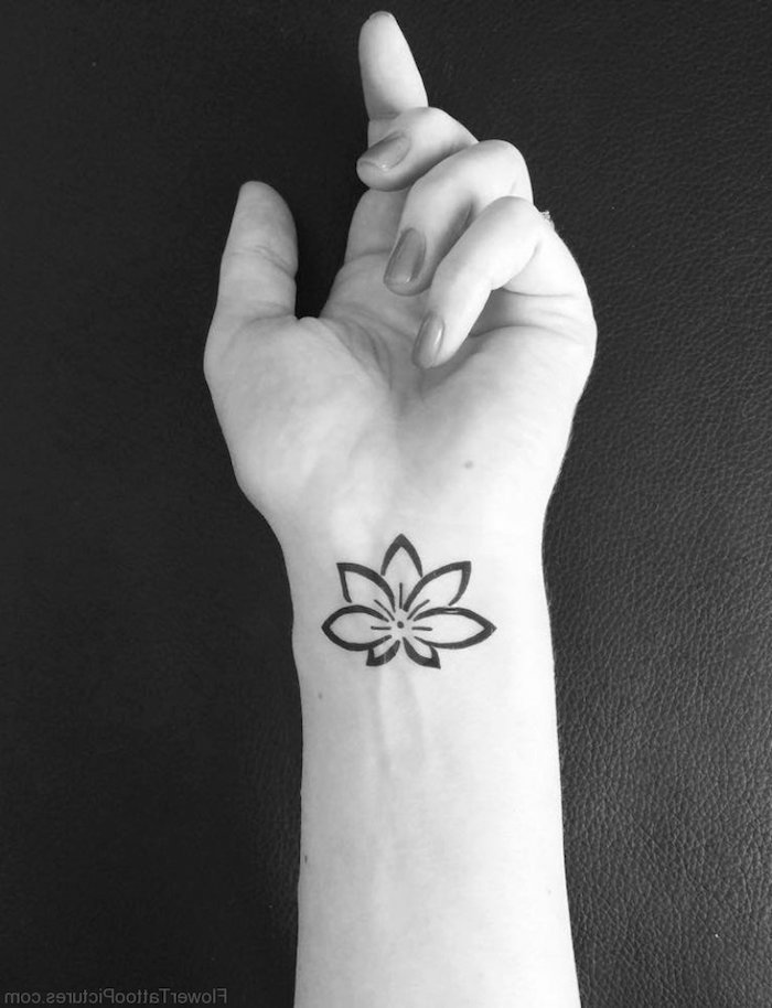 La main d'une personne avec tatouage poignet noir encre, les lignes d'une belle fleure, main de femme avec manucure, photo noir et blanc