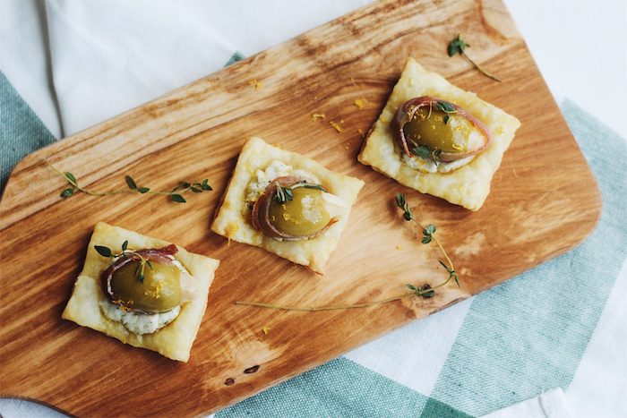 carré de feuilleté avec fromage aux herbes fraiches, prosciutti et olives, amuse bouche pate feuilletée