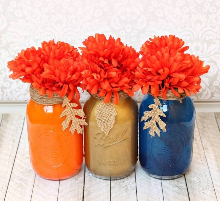 pots en verre repeints de peinture à l intérieur avec des fleurs orange, bord décoré de ficelle et feuilles de jute