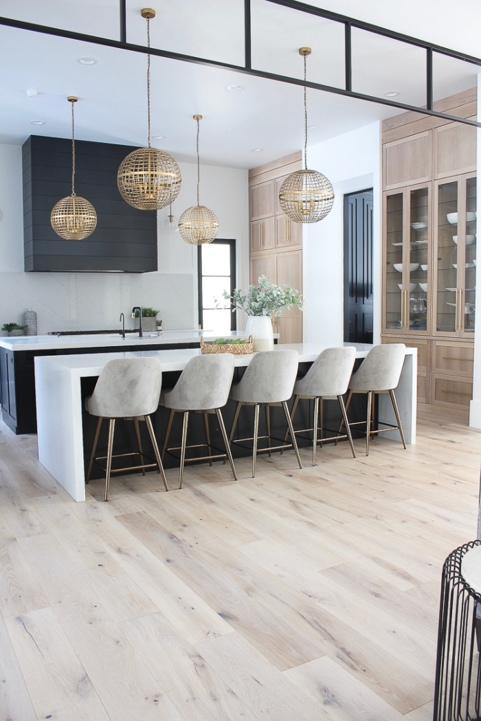 design intérieur contemporain aux murs blancs avec plancher bois, modèle chaises bar effet ciment, idée cuisine noir et blanc