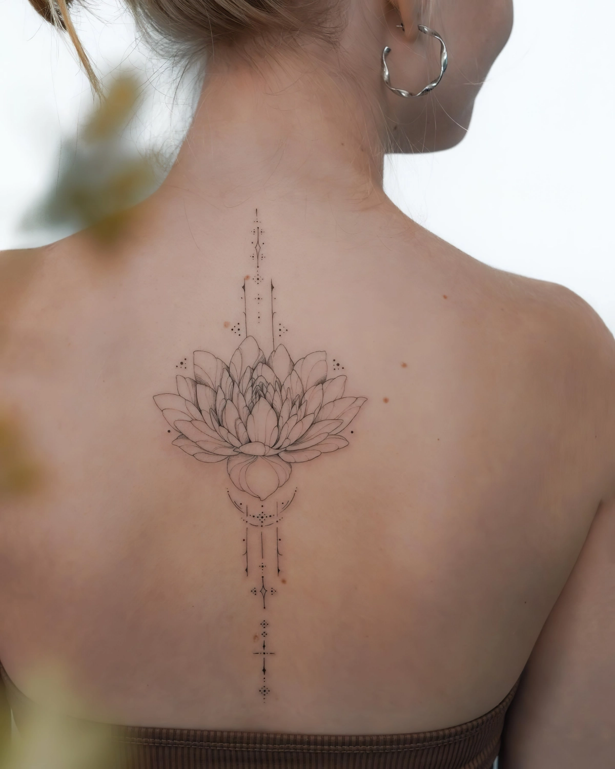 tatouage dos lotus fleur creoles cheveux blonds attaches corps visage