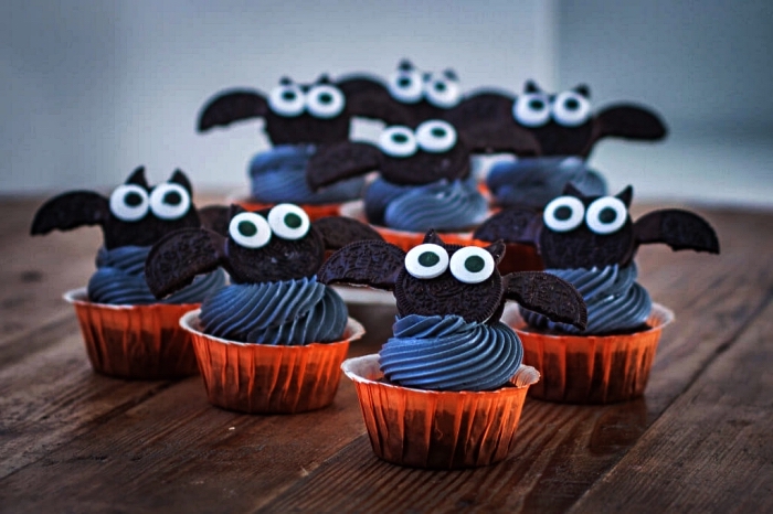 cupcakes d'halloween au glaçage noir décorés de chauves-souris en biscuits oreo, dessert simple et rapide pour le repas halloween