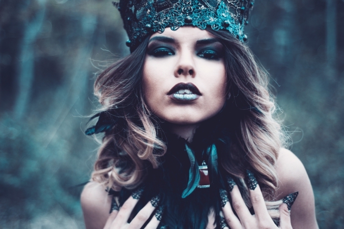 déguisement-femme-sorcière-halloween-maquillage-lèvres-yeux-foncés-manucures-ongles-longs-nature-forêt idée fond ecran halloween avec une femme masquée comme une sorcière avec couronne et ongles longs à maquillage foncé