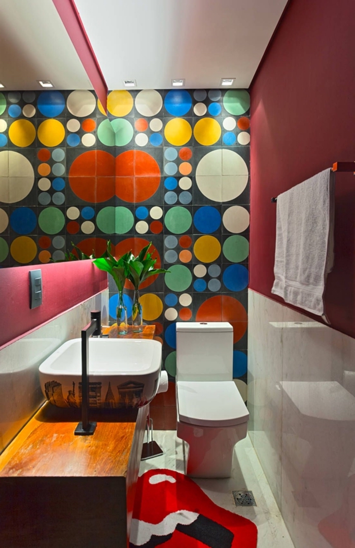 deco toilettes originales, modèle toilettes aux murs rouges avec faïence multicolore aux motifs géométriques