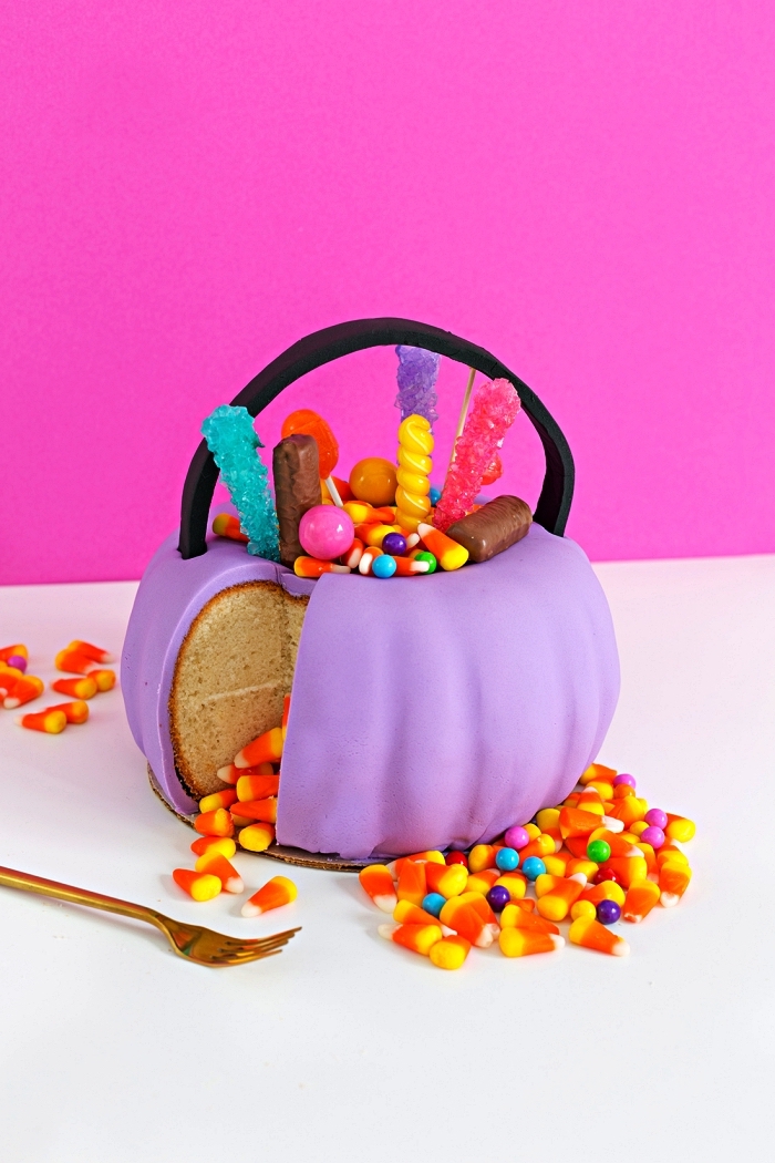 gateau d'halloween en forme de citrouille au glaçage en pâte à sucre violet, décoré de confiseries d'halloween