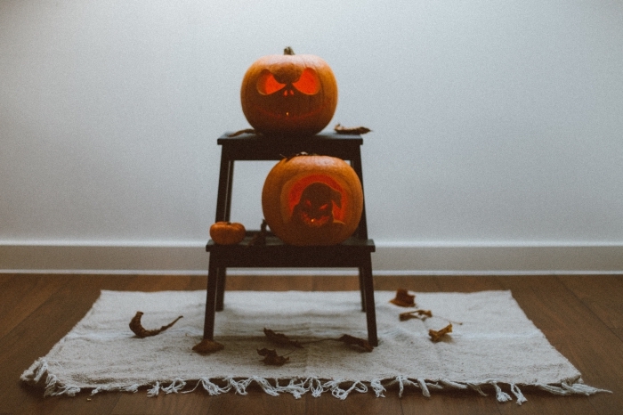diy décor pour halloween avec citrouilles jack'o, idée citrouille halloween sculptée posée sur table bois basse