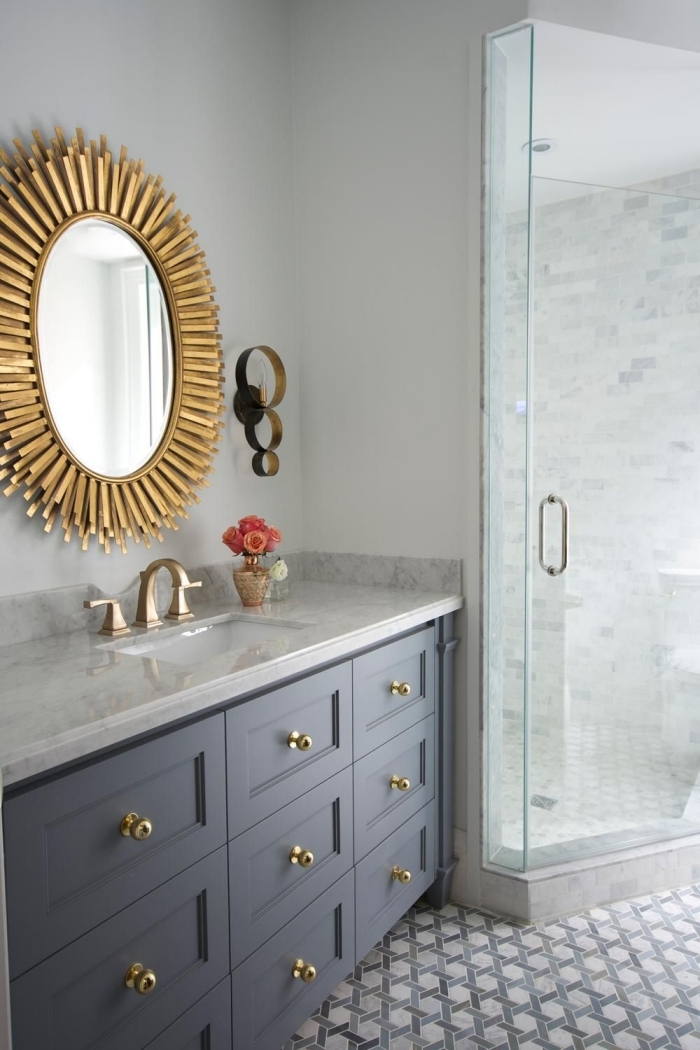 modèle de miroir en bois dans une salle de bain aux murs blancs avec carrelage sol motifs hexagonaux et finitions dorées